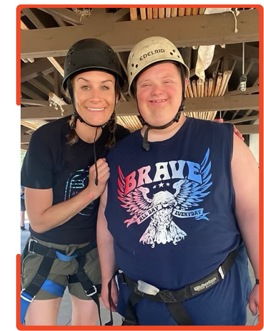 Amplify Life staff member and participant in climbing helmets smiling together
