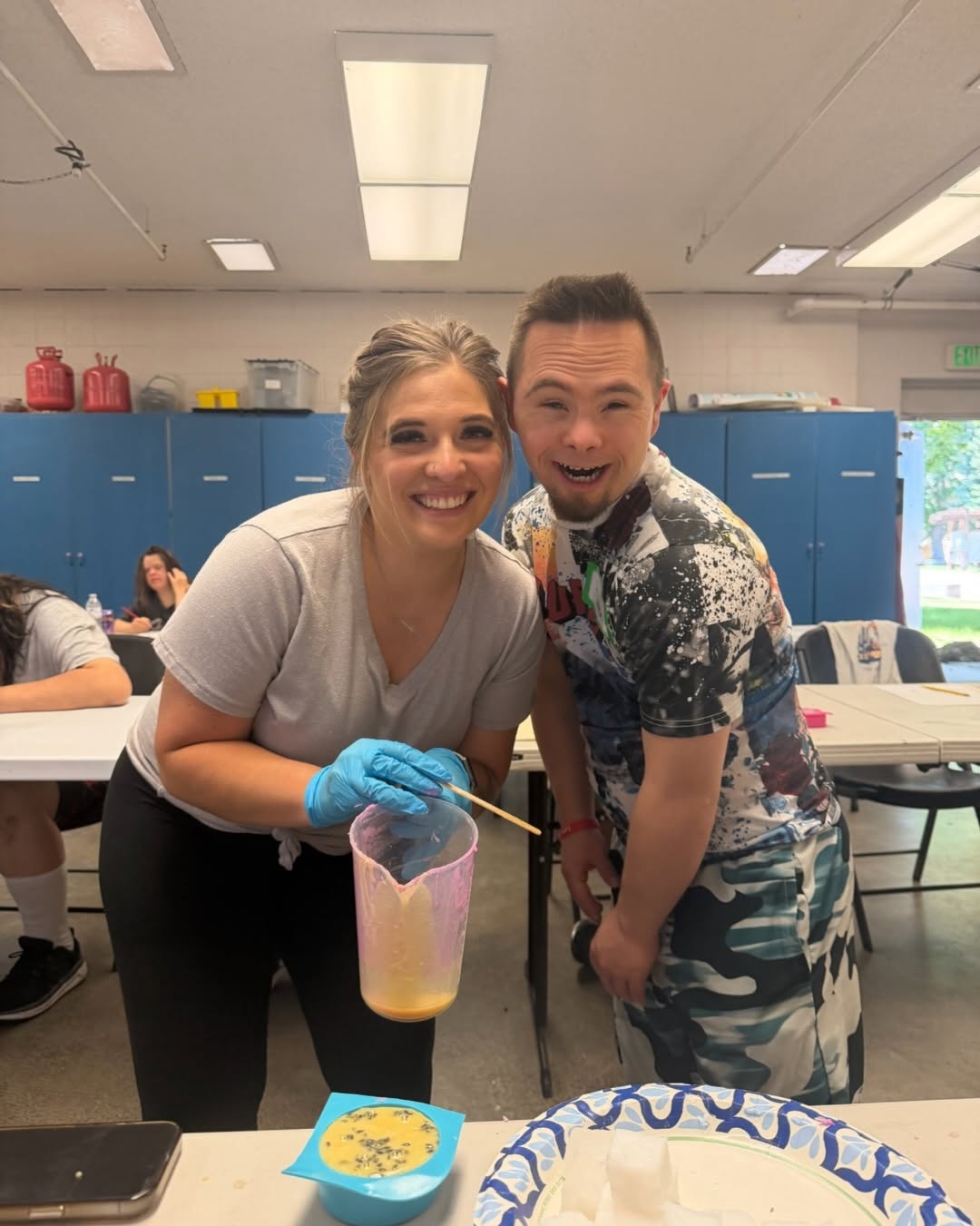 Staff member and participant making soap together