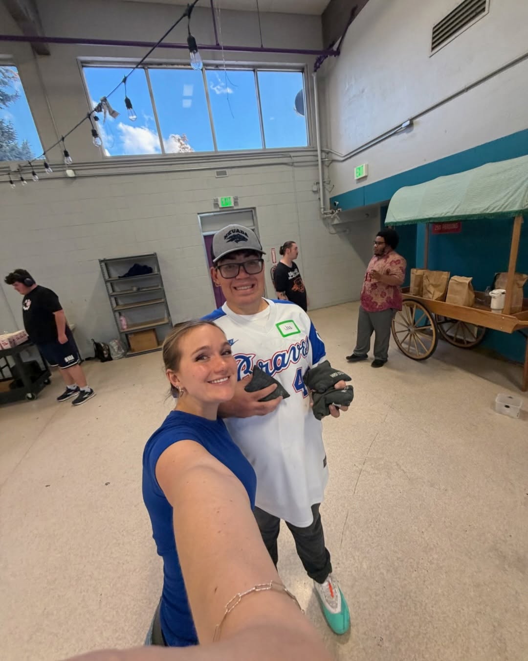 Staff member taking a selfie with a participant in a Braves jersey