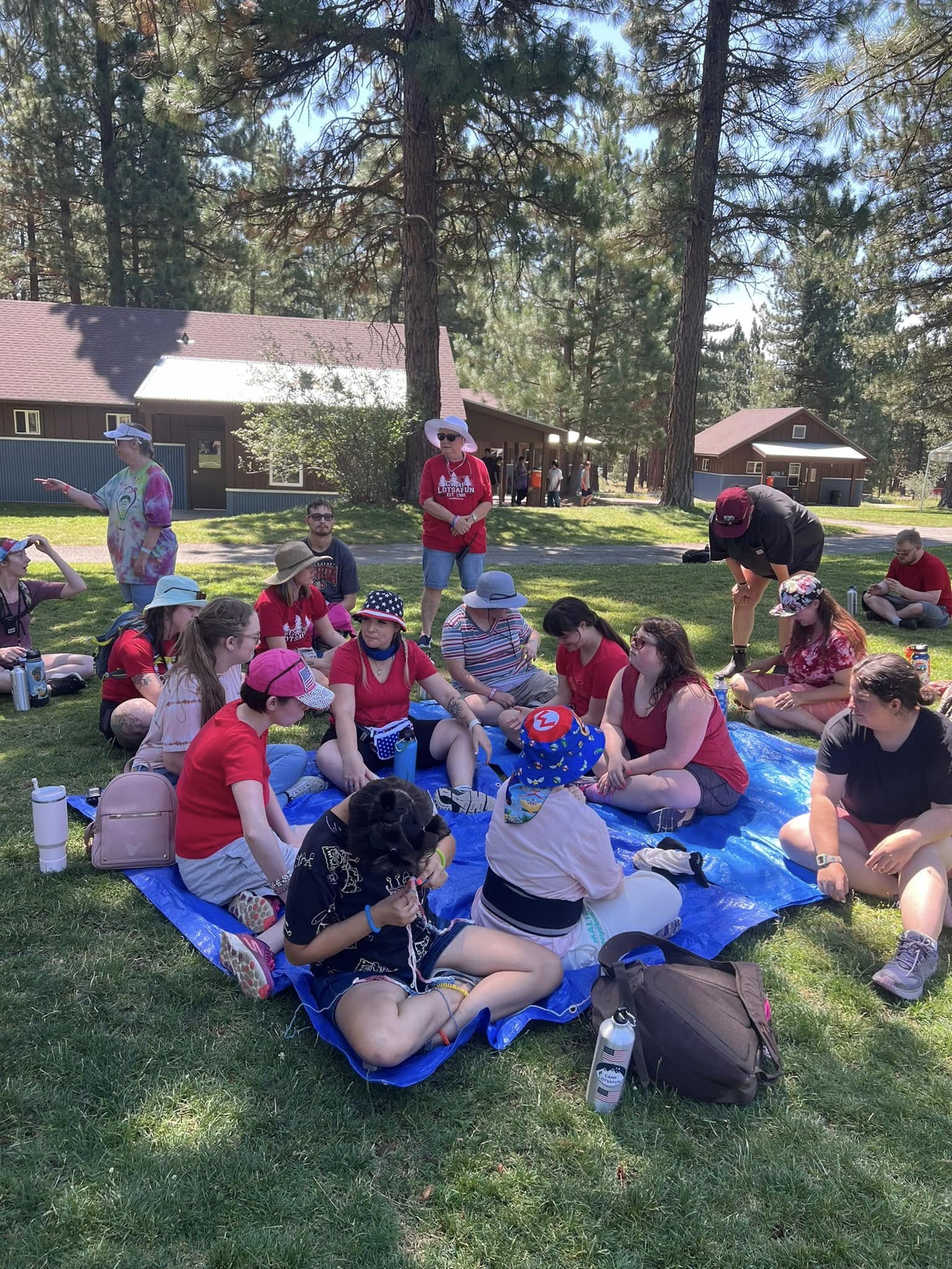 Campers on picnic blankets in the pines
