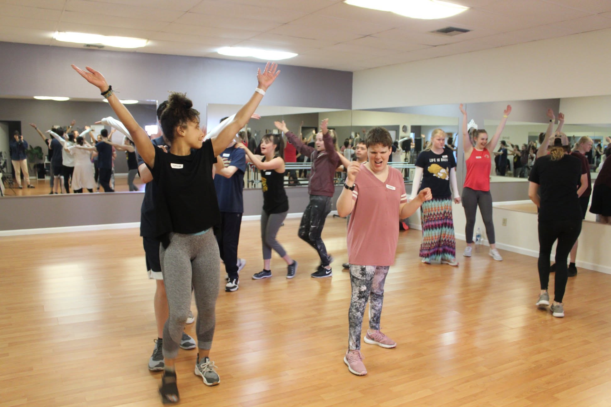 Dancers practicing moves in a mirrored studio